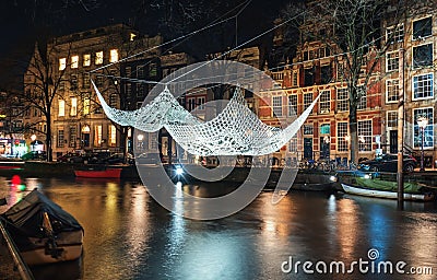 Crochet and illuminated giant bedspread float above a canal during the Festival of Light in Amsterdam Editorial Stock Photo